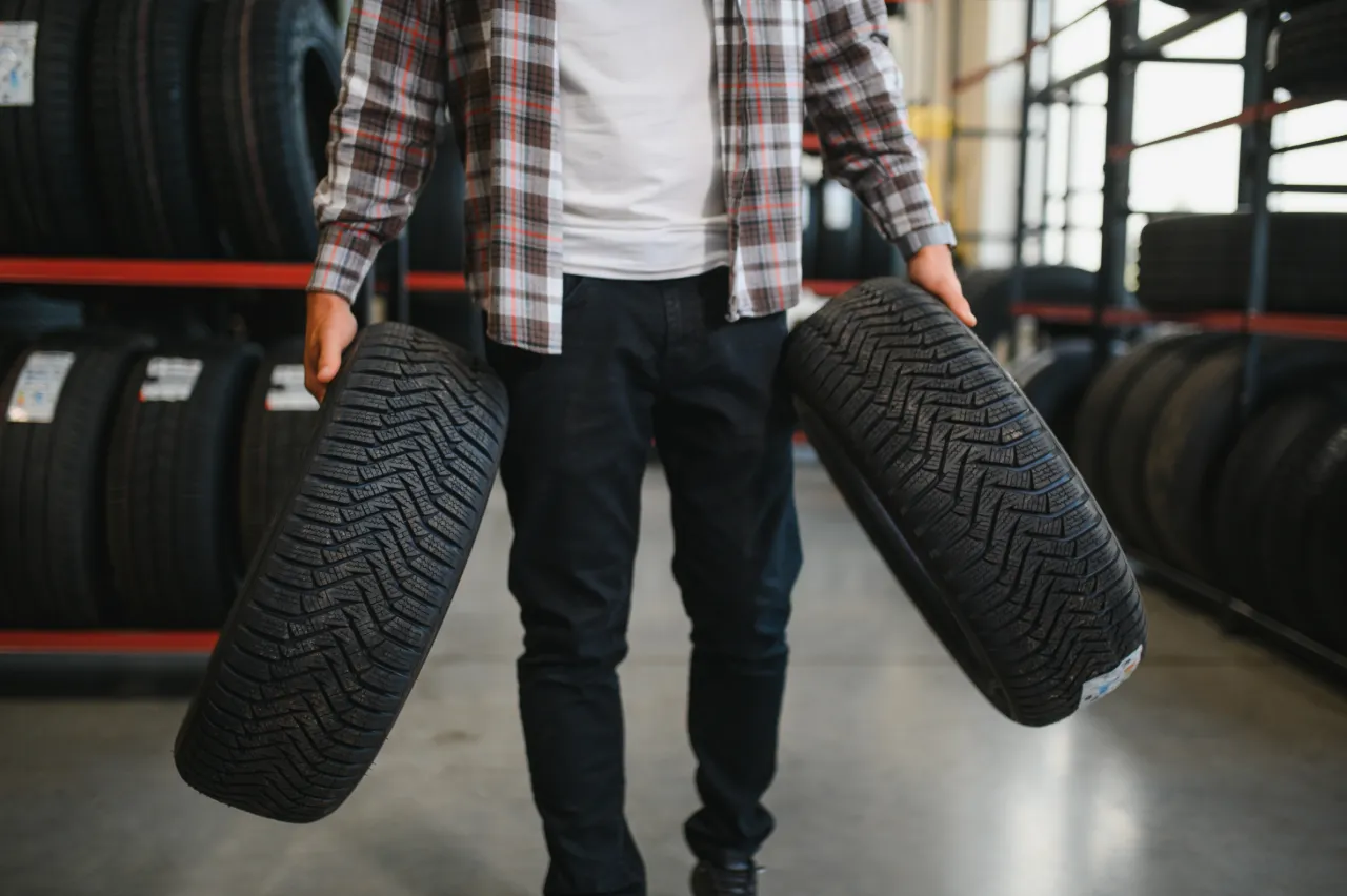 Customer holding new tyres in a tyre shop