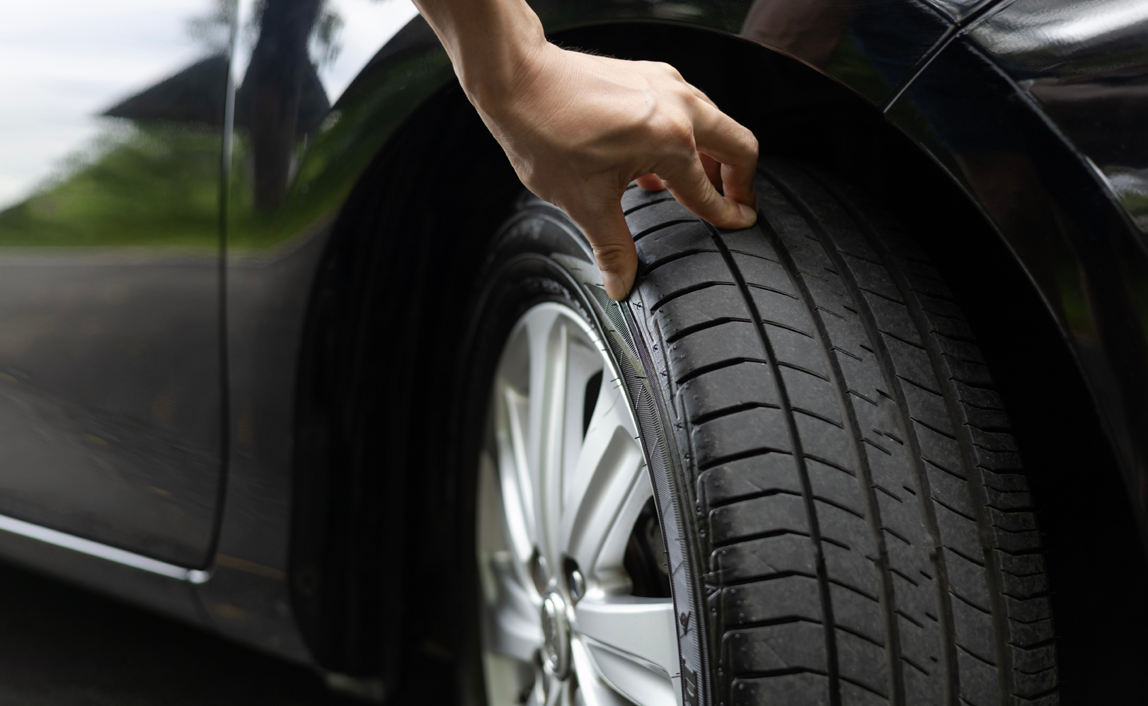 A man checking his tyres after a successful replacement